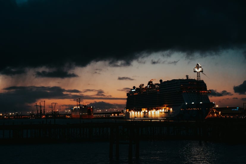 A cruise ship and container vessel in Southampton Port at night