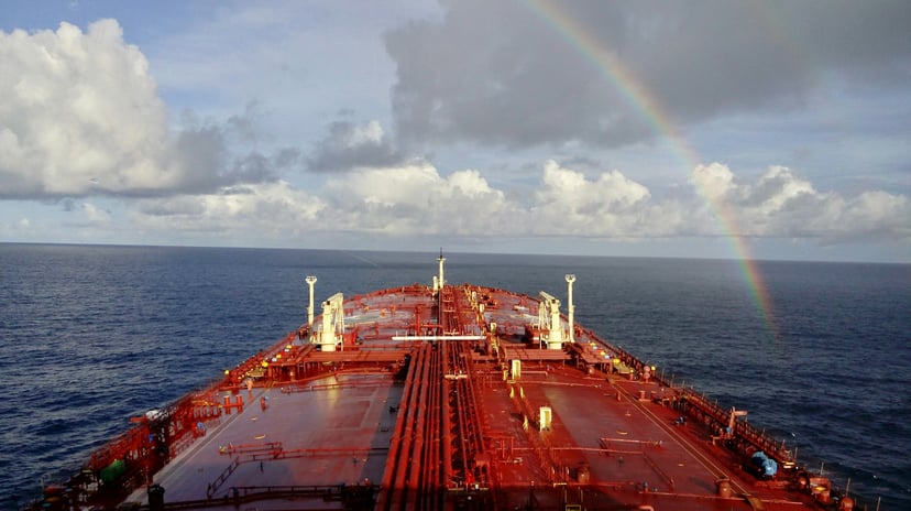 A tanker sailing towards a rainbow