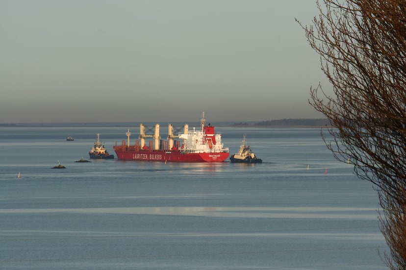 a bulk carrier and tugboats