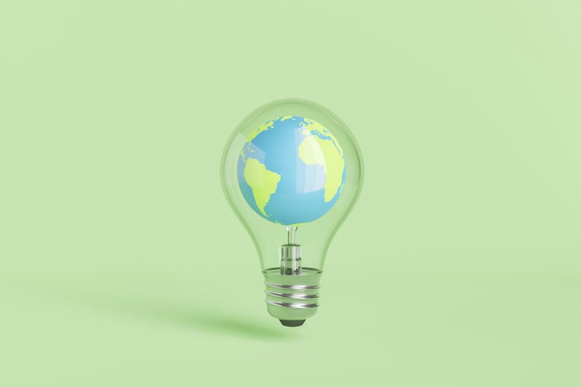 a world globe inside a lightbulb on a green background