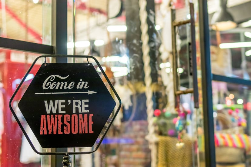 a sign outside a business saying 'come in, we're awesome'