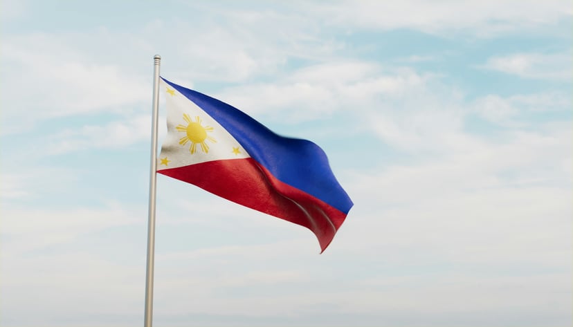 The flag of the Philippines flying against a blue sky