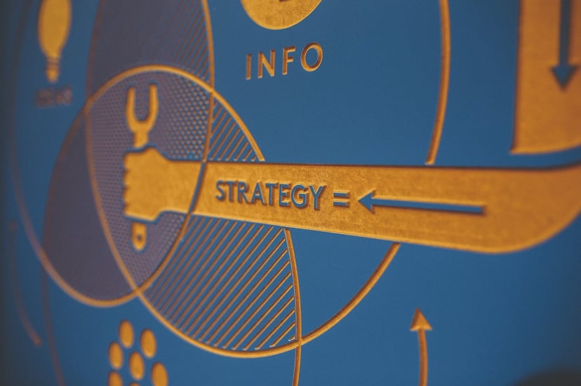 A design including a pie chart and an arm holding a wrench with the word 'strategy' on it