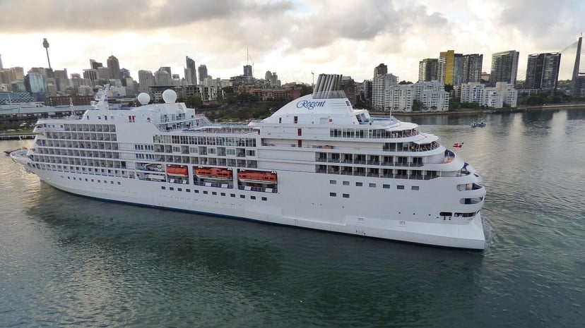 The Regent Seven Seas Navigator cruise ship sailing near a city