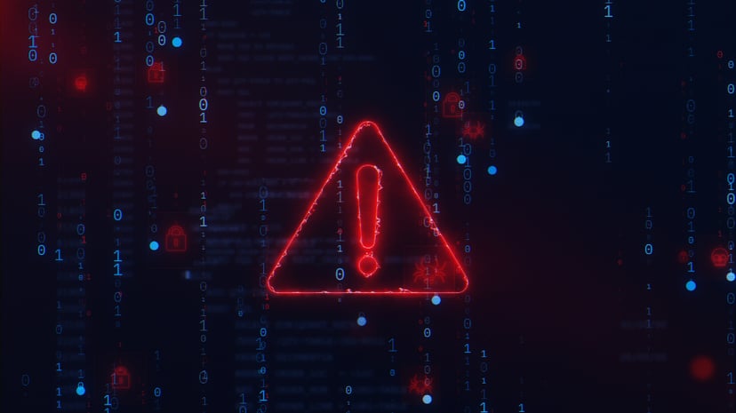 A neon exclamation mark in front of code on a monitor 