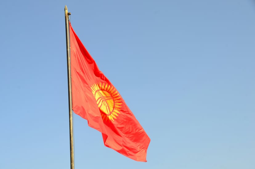 The flag of Kyrgyzstan against a blue sky