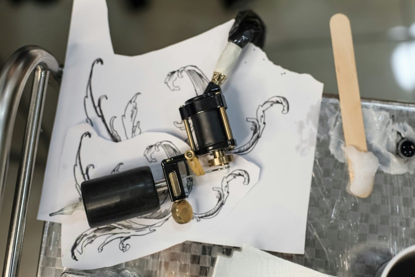 A tattoo design and tattoo gun in a tattoo studio
