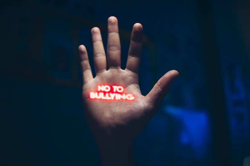 The palm of a hand with the words 'No to bullying' projected onto it in red