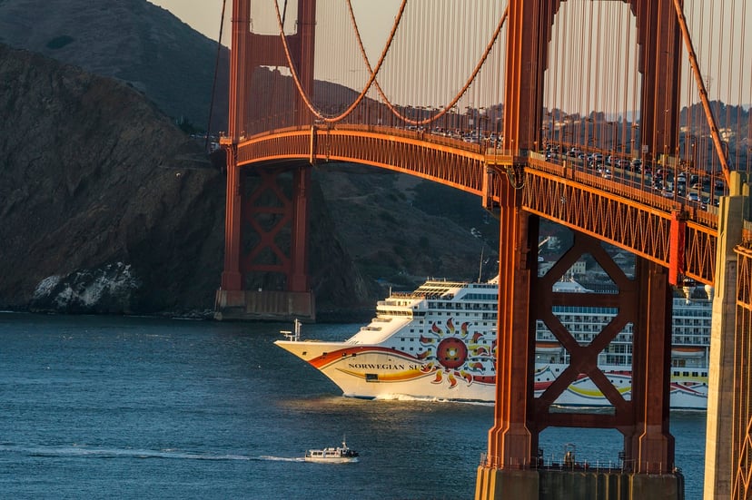 The Norwegian Sun cruise ship sailing beneath a suspension bridge