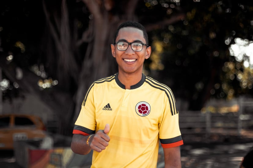 a smiling man giving a thumbs up sign