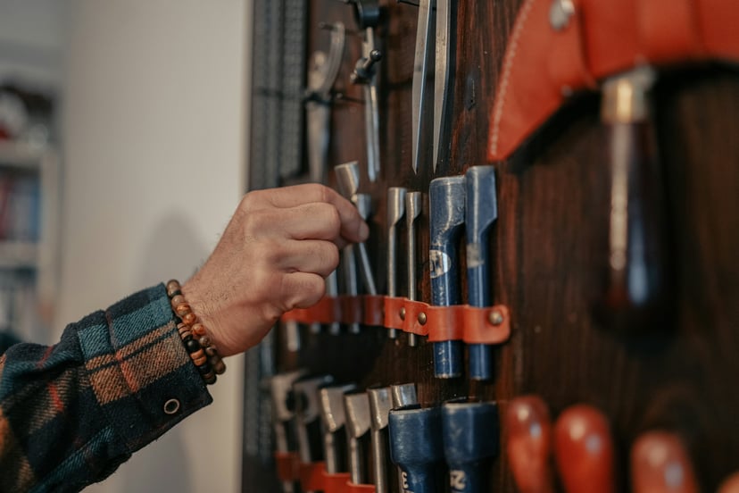 A hand selecting a tool from a selection displayed on a wall