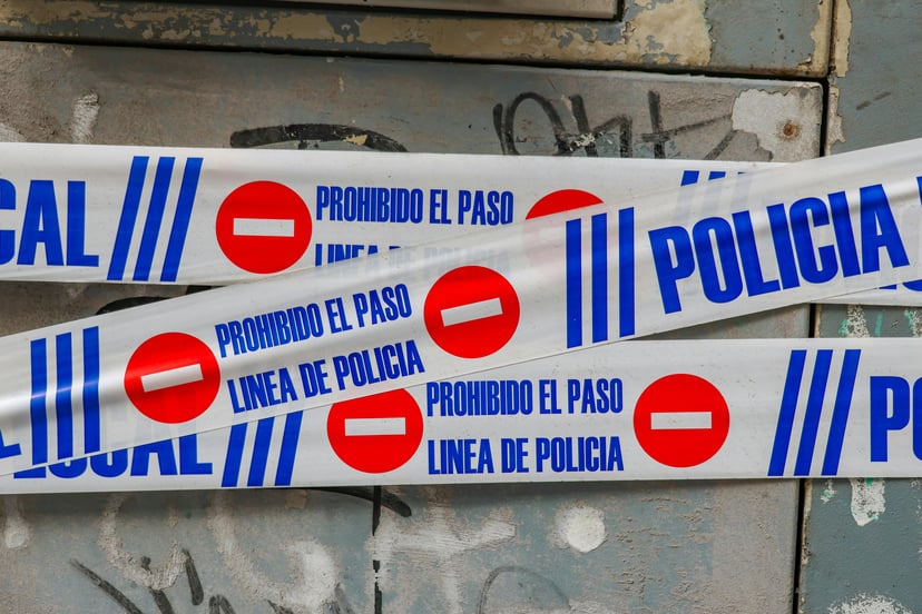 Spanish police tape with the words 'prohibido el paso linea de policia'