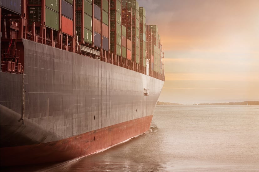 the hull of a container ship at sunset