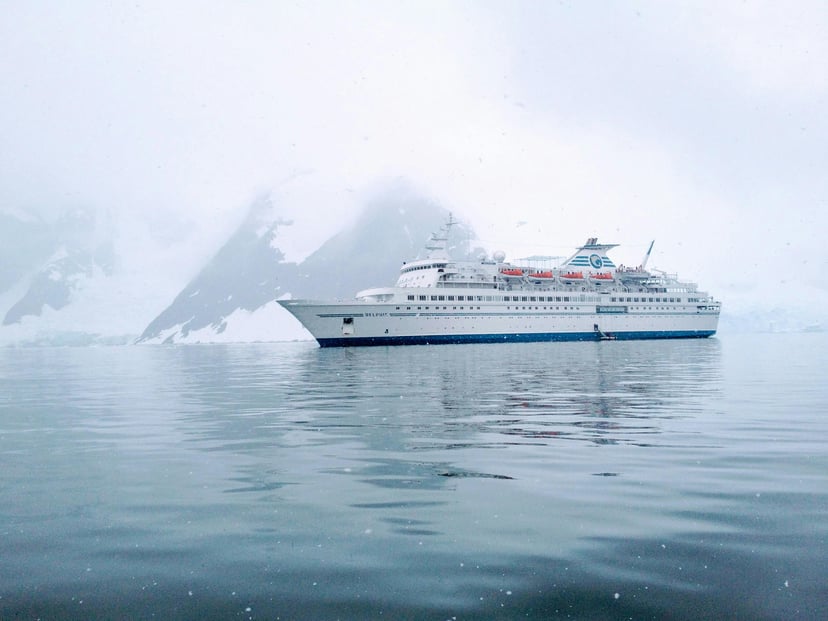 a small cruise ship sailing through the Antarctic