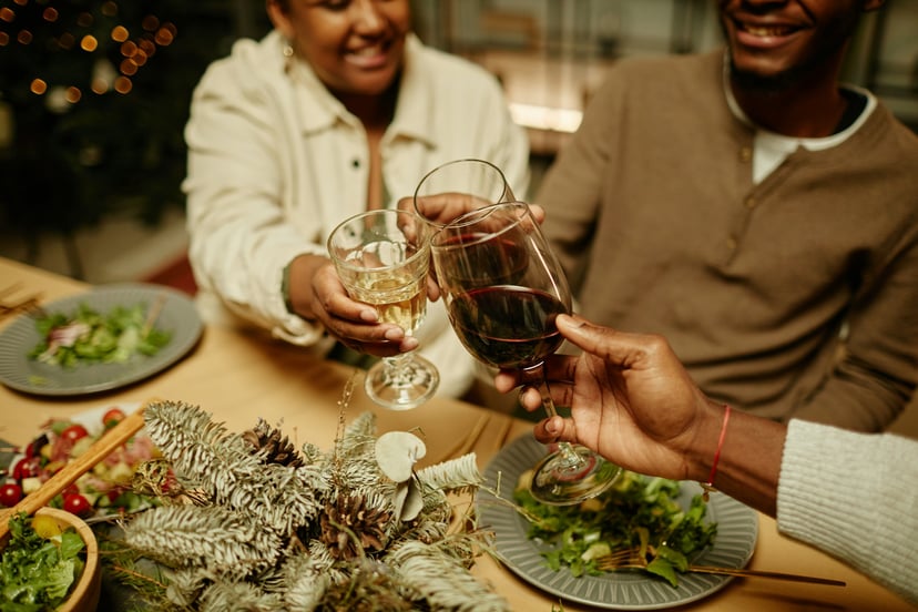 family clinking glasses over Christmas dinner