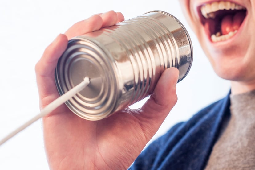 A person shouting into a tin can 'telephone'