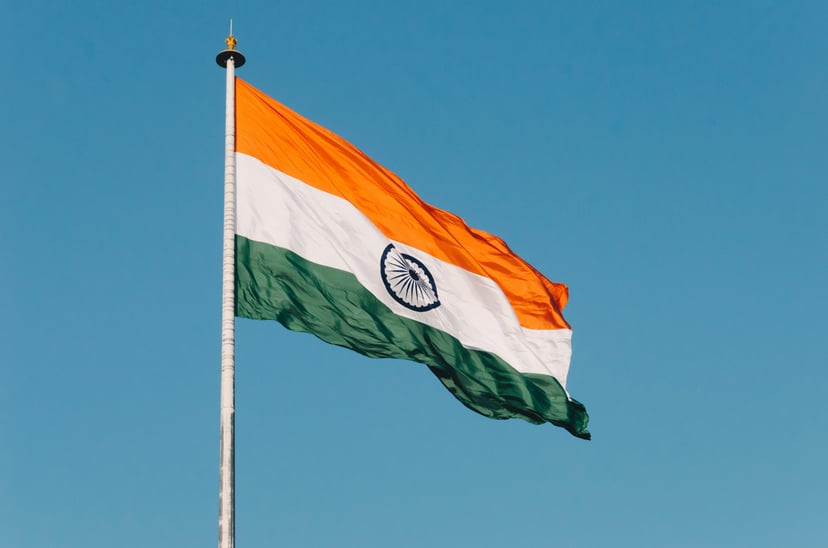 The flag of India flying against a blue sky
