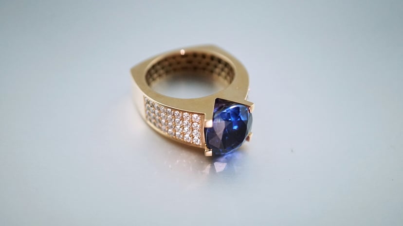 A gold ring encrusted with diamonds and a sapphire
