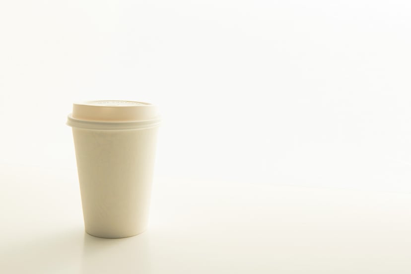 A beige colored reusable coffee cup
