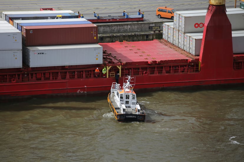 a pilot boat pulling up to a large cargo ship