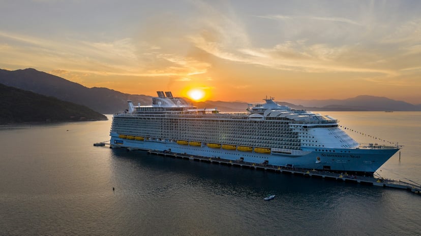 The Symphony of the Seas cruise ship near an island at sunset
