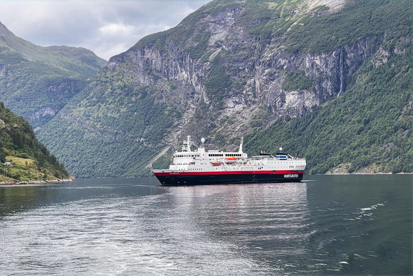 a Hurtigruten expedition ship surrounded by mountains