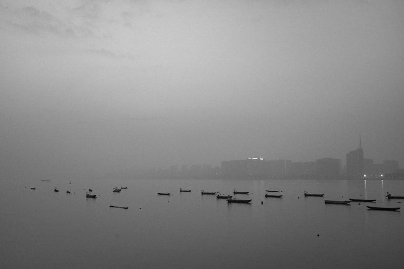 small boats moored in a foggy harbor with low visibility