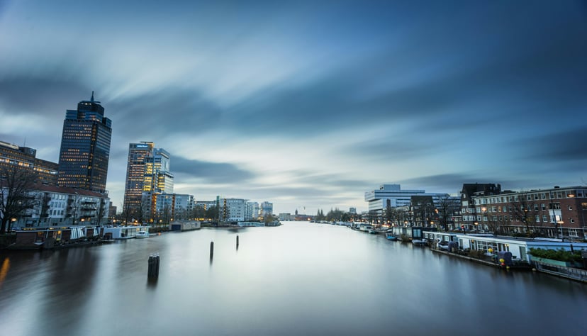The Amstel River in Amsterdam under a grey cloudy sky