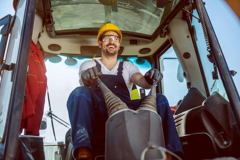 a smiling excavator driver at work in his cab
