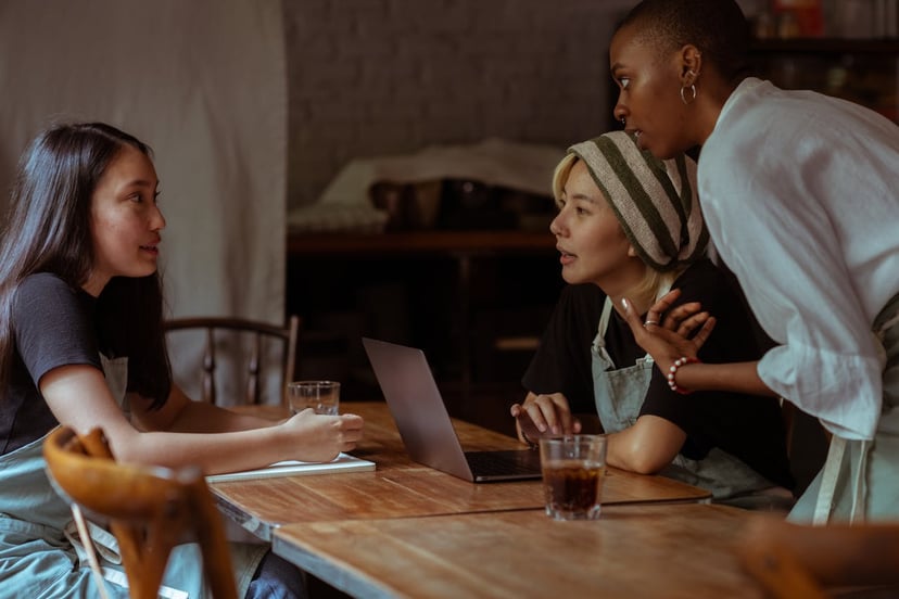 coworkers gathered around a laptop