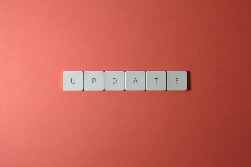 The word 'update' spelt out on tiles on an orange background