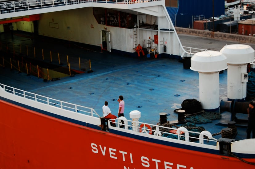 two men standing on the deck of a commercial vessel