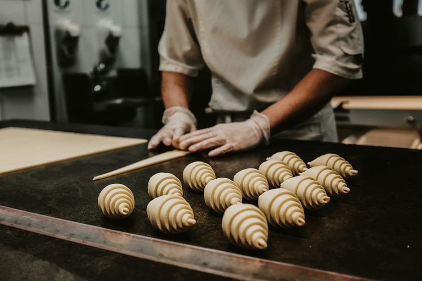 A pastry chef making croissants in a professional kitchen
