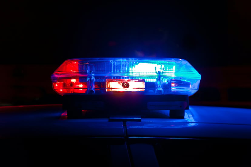 A blue and red flashing light on the top of a police car
