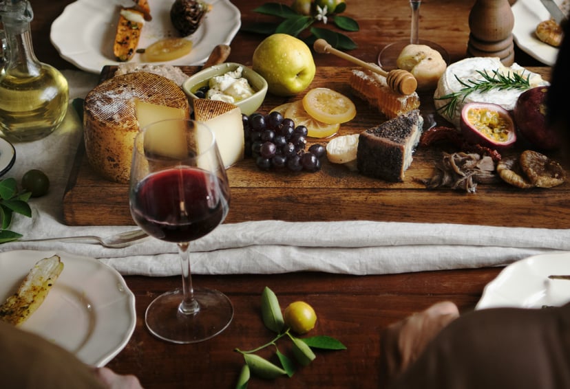 A glass of red wine and a cheese board