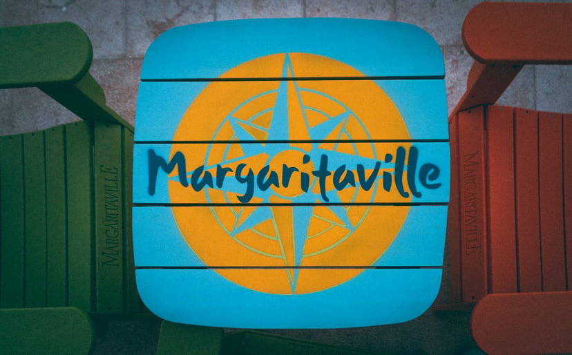 The Margaritaville logo painted on a wooden beach table