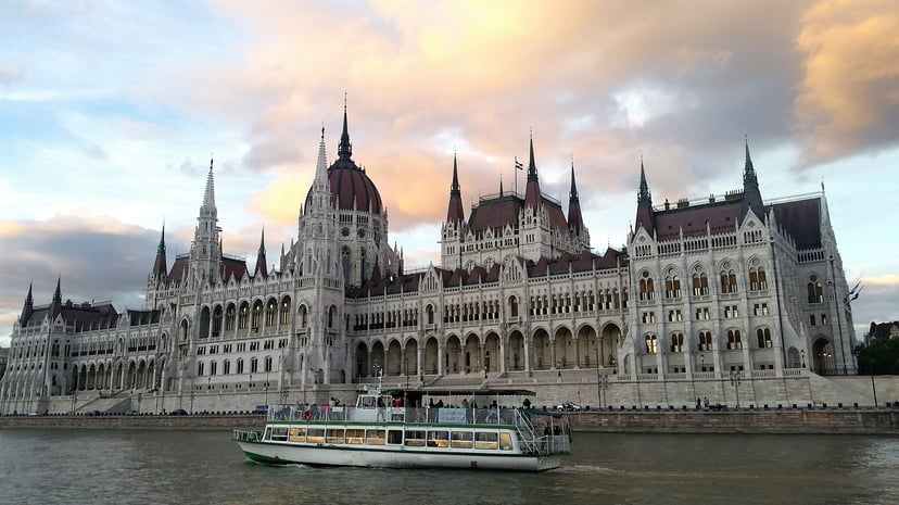 A river cruise boat sailing past the Hungarian Parliament buildings on the Danube River