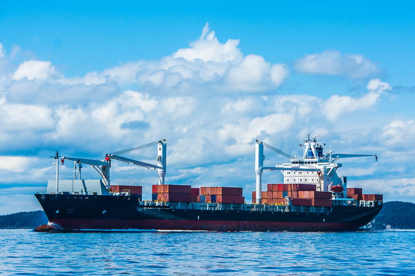 a smaller sized container ship sailing near the coast