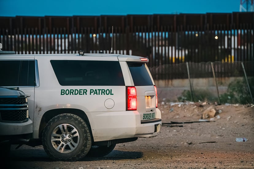 A Border Patrol vehicle near a fenced off area