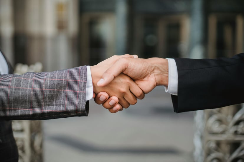 The hands of two men in business attire shaking hands