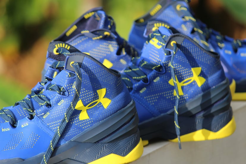 A pair of blue sneakers with the yellow Under Armour logo on them