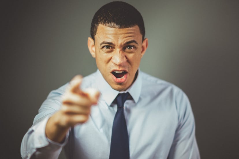 An argumentative man pointing his finger at the camera