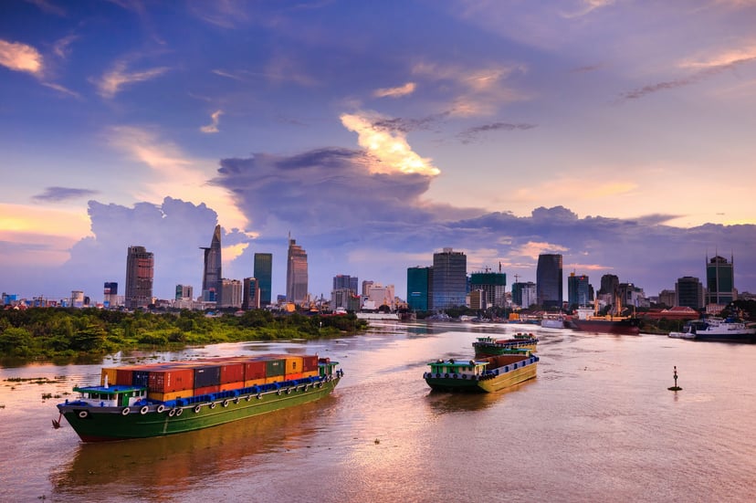 Container ships sailing past a city skyline