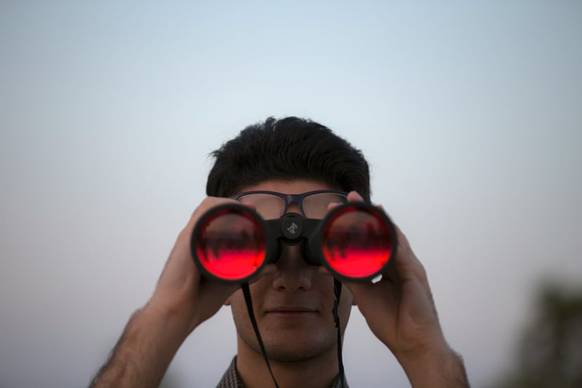 A man looking through binoculars