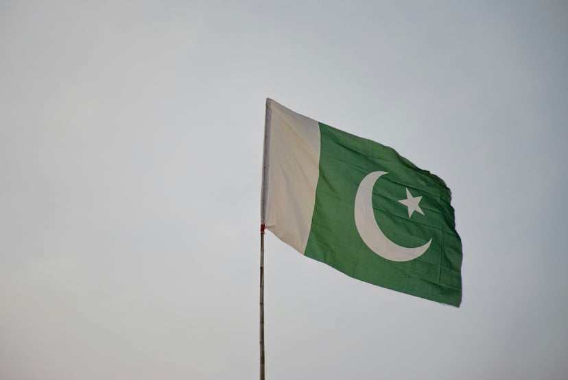 The flag of Pakistan raised against a grey sky