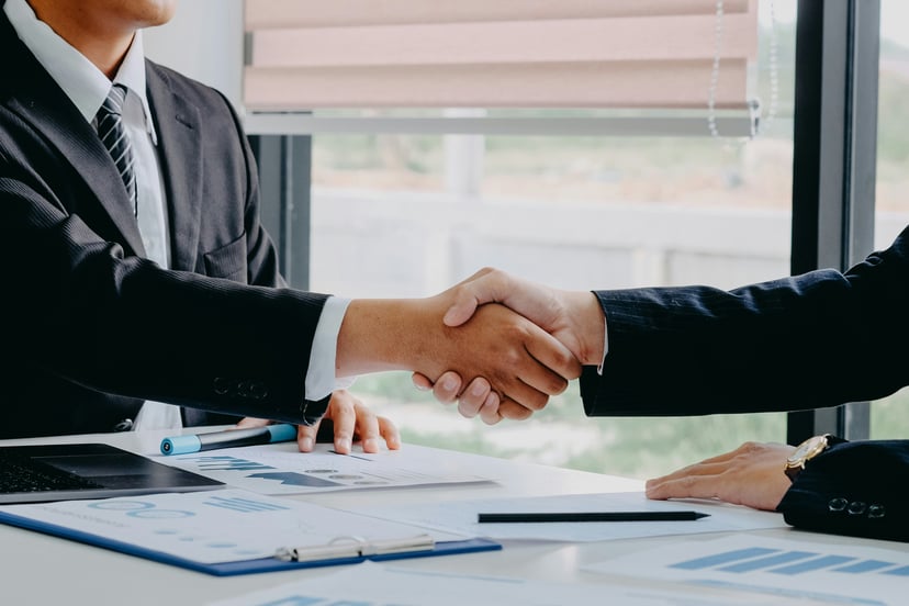 people in business attire shaking hands