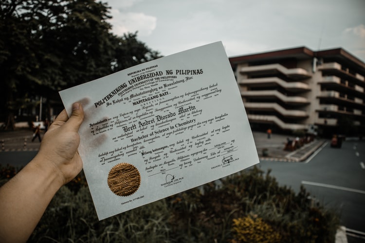 a hand holding up a certificate