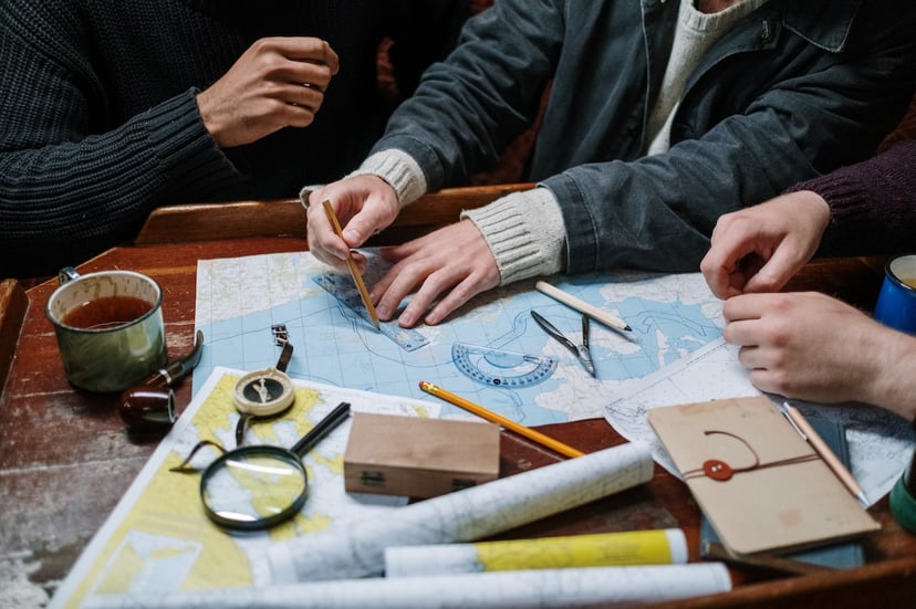 man drawing on a nautical chart while working in a navigation officer job