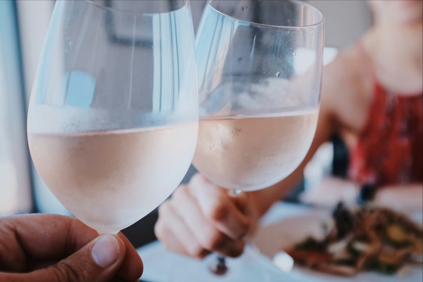 people clinking two glasses of rose wine