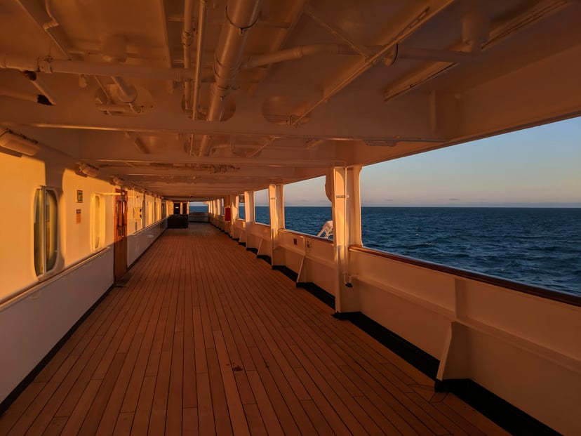 The walkway on deck of a cruise ship at dusk
